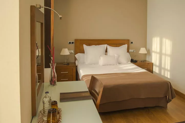 Habitación de hotel individual con cama, mesillas y escritorio